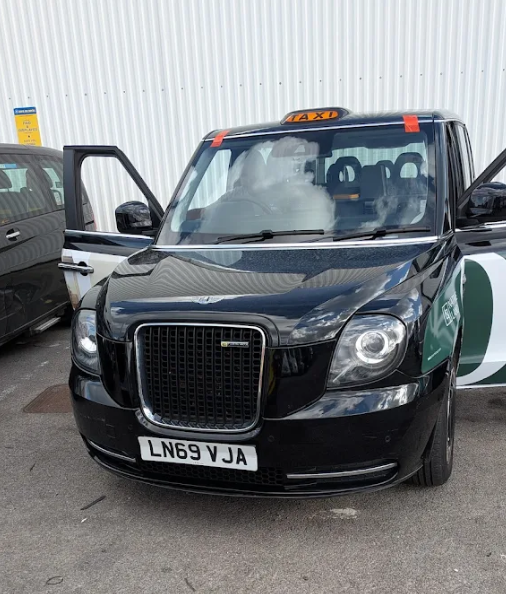 Black cab glass replacement on a London LEVC TX taxi — front windscreen being fitted
