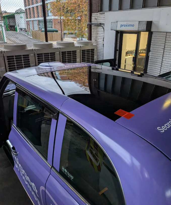 Roof glass replacement on a purple vehicle — panoramic sunroof glass being fitted