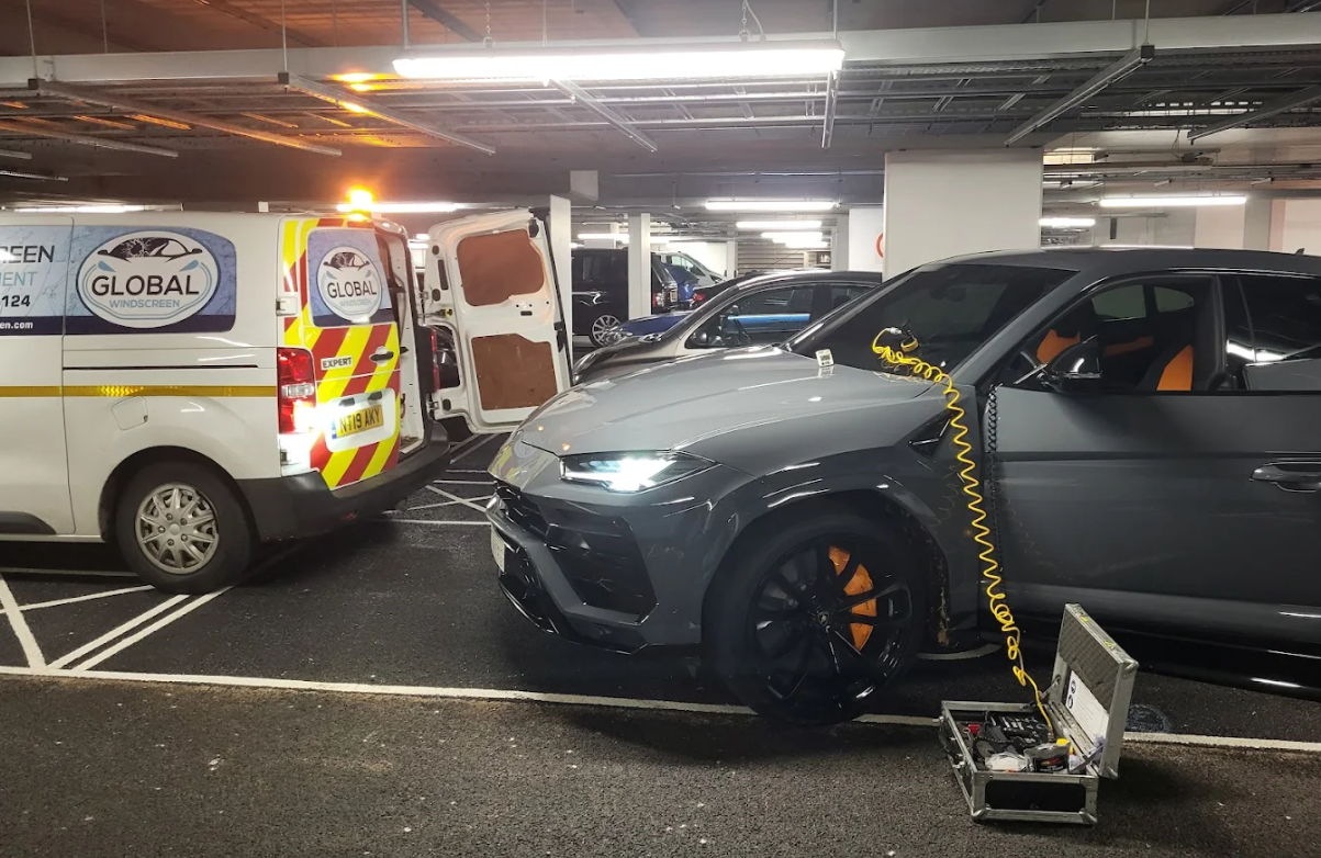 Global Windscreen van alongside a Lamborghini Urus during windscreen replacement in a London car park